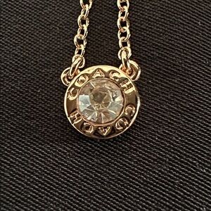Coach NWOT rose goldtone necklace. Round CZ bezel set stone w/ chain & extender